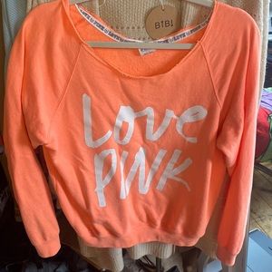 Bright orange small Victoria’s Secret sweater falls off the shoulder